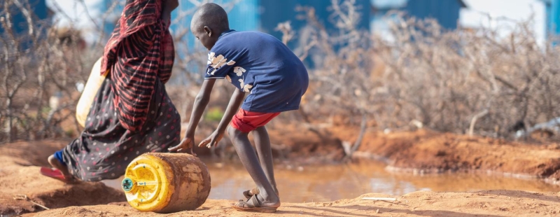 Мальчик катит емкость с водой в Доллоу у границы Сомали с Эфиопией.